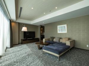 a living room with a couch and a tv at KOKO HOTEL Premier Hakata in Fukuoka