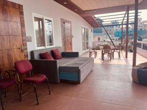 a living room with a couch and a table and chairs at Soar Serenity Homes in Pithorāgarh