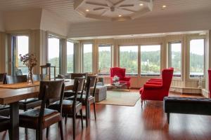 a living room with a table and chairs and windows at Villa Oleanna in Lysekloster