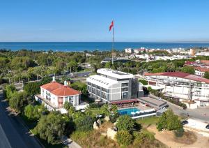 a building with a flag on top of it next to the ocean at Side Square Hotel Adults Only in Side
