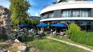 a building with people sitting under blue umbrellas at Side Square Hotel Adults Only in Side