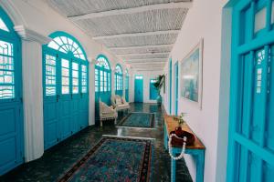 a hallway with blue doors and rugs at Al Bait Al Sharqi in Muscat