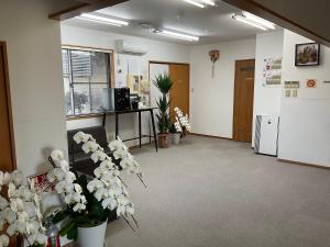 an office lobby with white flowers in at Hotel Morimotoya 板野店 in Kamiita