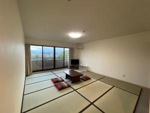 a living room with a table and a large window at Hotel Morimotoya 板野店 in Kamiita