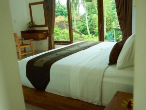 1 dormitorio con 1 cama blanca grande y ventana en Eden House Ubud, en Ubud