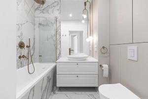 a white bathroom with a sink and a toilet at Tesoro Dolce Vita Apartment in Pogórze