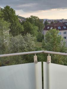 a balcony with a white fence and trees at Apartment Robin in Karlovy Vary