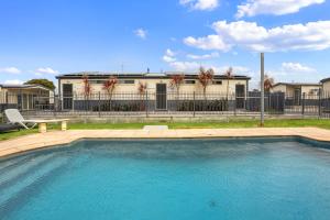 a swimming pool in front of a building at Apollo Bay Holiday Park in Apollo Bay