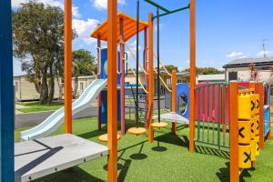 a playground with colorful slides and swings at Apollo Bay Holiday Park in Apollo Bay