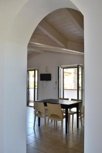 a dining room with a black table and chairs at Appartamenti In Residence Zoe in Roseto degli Abruzzi