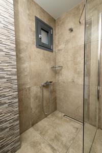 a bathroom with a shower with a glass door at Filoxenia Studios in Afitos +19 photos