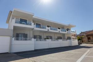 a large white building with a white fence at Filoxenia Studios in Afitos