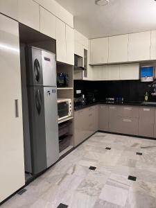 a kitchen with a refrigerator and a microwave at Cozy Loft 201 2 BHK in Jaipur