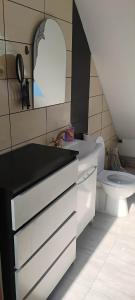 a bathroom with a white sink and a toilet at Lipowy domek Mazury in Piecki