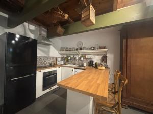 a kitchen with a black refrigerator and a wooden counter top at Gîte casa cosy in Salies-de-Béarn
