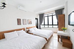 a bedroom with two beds and a window at Chichi Inn Hotel CoTo in Đảo Cô Tô