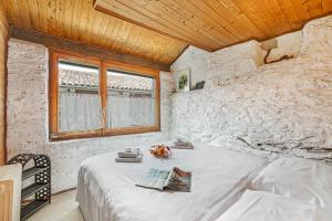 a bedroom with a white bed in a stone wall at Rustico Stock with free wifi- Happy Rentals in Lugano