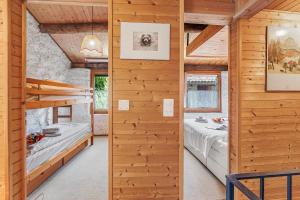 two beds in a room with wooden walls at Rustico Stock with free wifi- Happy Rentals in Lugano