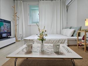 a living room with a coffee table with flowers on it at 행궁동-House1 in Suwon