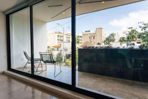 a room with a large window with chairs on a balcony at Beautiful apartment Top location! in Playa del Carmen