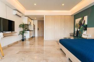a bedroom with a blue bed and a kitchen at Beautiful apartment Top location! in Playa del Carmen