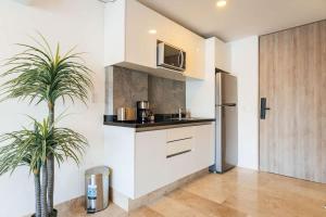 a kitchen with a sink and a refrigerator at Beautiful apartment Top location! in Playa del Carmen +16 photos