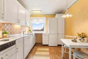 a kitchen with white cabinets and a white refrigerator at Reine Panorama in Reine