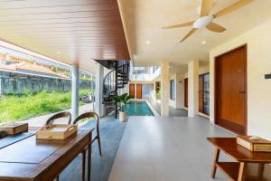 a living room with a table and a ceiling fan at Sekala CoLiving Canggu - Minutes away to Finns and Atlas Beach Clubs in Canggu