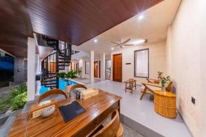 an open living room with a wooden desk and wooden ceilings at Sekala CoLiving Canggu - Minutes away to Finns and Atlas Beach Clubs in Canggu