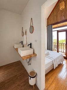 a bathroom with a bed and a sink on a wall at MHARI Bungalows and Rooms in Tubod
