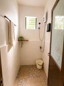 a bathroom with a shower with a toilet and a window at MHARI Bungalows and Rooms in Tubod +41 photos