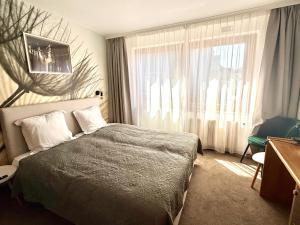 a hotel room with a bed and a window at Hôtel Albert 1er in Malmedy