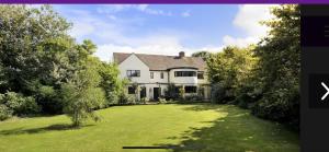 a large white house with a large yard at Hadrian House in East Preston