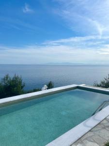 a swimming pool with a view of the ocean at Koumaros Villas in Agia Paraskevi