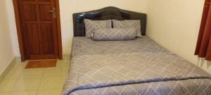 a bed with a black headboard in a room at Pin senaru accomodation in Senaru