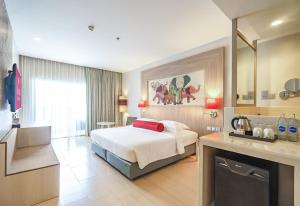 a hotel room with a bed and a bathroom at Ramada by Wyndham Phuket Deevana in Patong Beach
