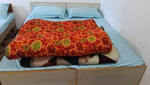 a bed with a colorful blanket on top of it at Punchkedar in Phata