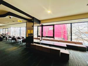 a waiting room with benches and tables and windows at Hotel The Centre Utsunomiya in Utsunomiya