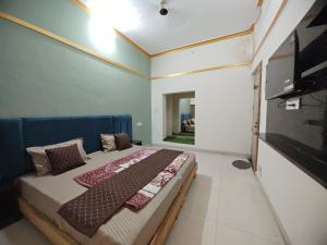 a bedroom with a bed and a flat screen tv at Nilaya in Varanasi