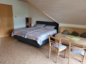 a bedroom with a bed and a table and a chair at Fewo-Minheim in Minheim
