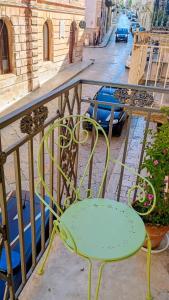a green chair sitting on top of a balcony at Old Town in Castellana Grotte