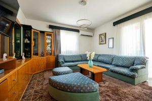 a living room with a blue couch and a table at S&T VILLA in Haraki +38 photos