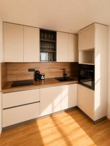 a kitchen with white cabinets and a wooden floor at Sealavie in Koper