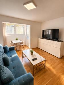 a living room with a blue couch and a table at Sealavie in Koper