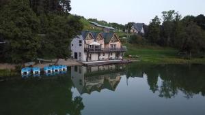 an aerial view of a house next to a lake at Stanica MODRAK - Najpiekniejszy ZAKĄTEK KASZUB in Ręboszewo