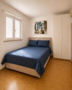 a bedroom with a bed with blue sheets and a window at Sealavie in Koper +7 photos