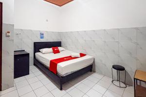 a bedroom with a bed with a red blanket at RedDoorz at Hotel AVA Malioboro in Jetis