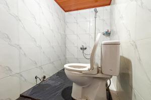 a bathroom with a white toilet in a room at RedDoorz at Hotel AVA Malioboro in Jetis +11 photos