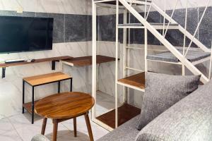 a room with a bed and a desk and a tv at RedDoorz at Hotel AVA Malioboro in Jetis