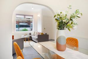 a living room with a table and a vase with flowers at Your Second Home - Work Stay - Free Parking in Bishop Auckland